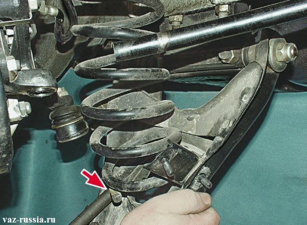 Поддевание монтажной лопаткой нижней части пружины, и снятие ее с автомобиля