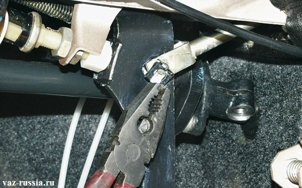 Снятие с помощью плоскогубцев стопорной скобы, с боковой части педали тормоза