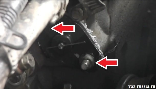 Стрелками указаны две гайки которые крепят натяжитель к двигателю автомобиля