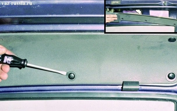 Поддевание с помощью отвёртки пистонов, которые удерживают обшивку двери багажника и вследствие чего снятие её