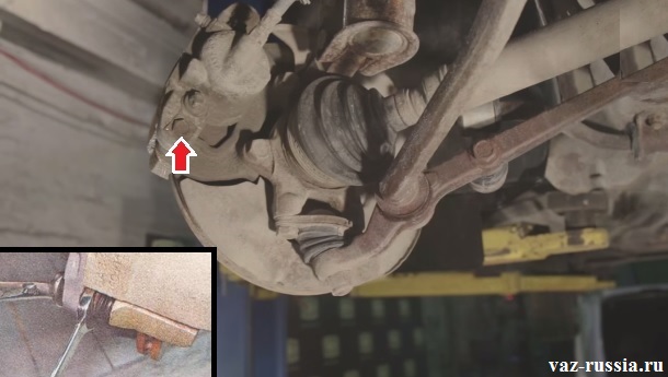 Выворачивание нижнего болта направляющего пальца крепления нижней части скобы тормозного суппорта
