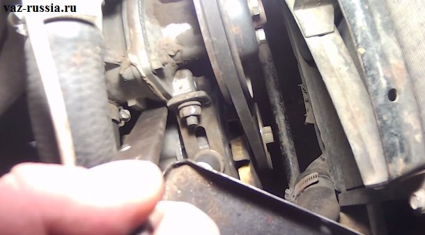 Отодвигание генератора при помощи монтажной лопатки от двигателя автомобиля и затягивание его гаек крепления