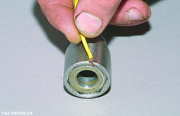 Вставление жилок от провода для того чтобы гайка крепления руля плотно закрепилась в головке и не выпадала из неё по мере закручивания